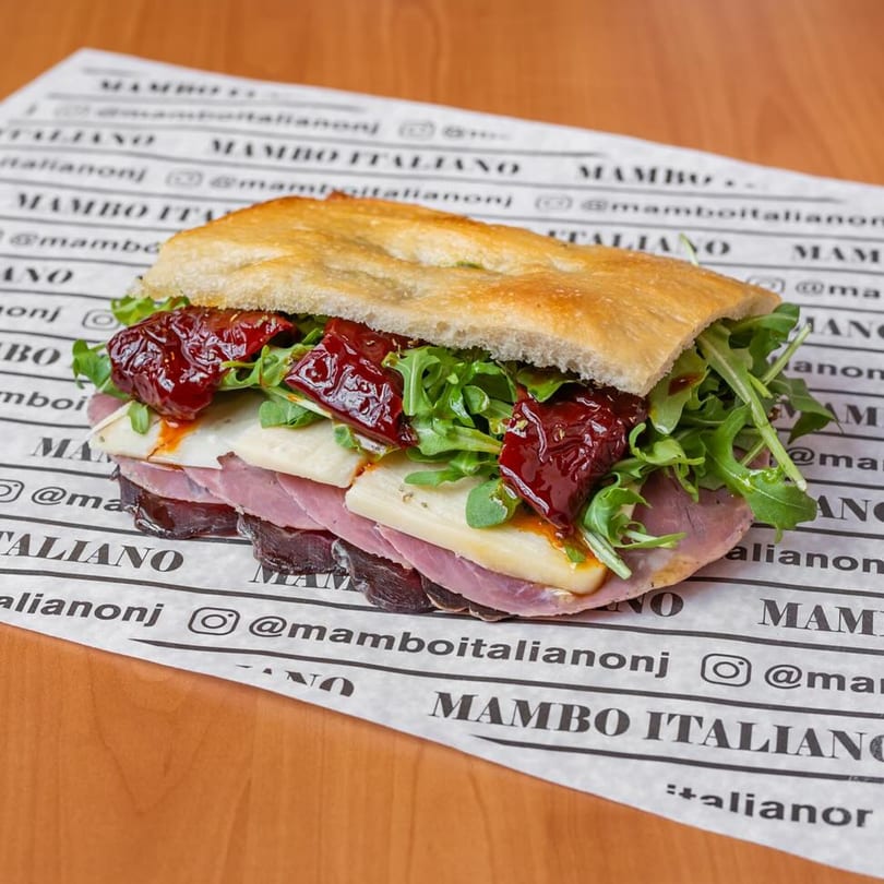 A Mambo Italiano sandwich with focaccia, prosciutto, cheese, arugula, and sun-dried tomatoes.
